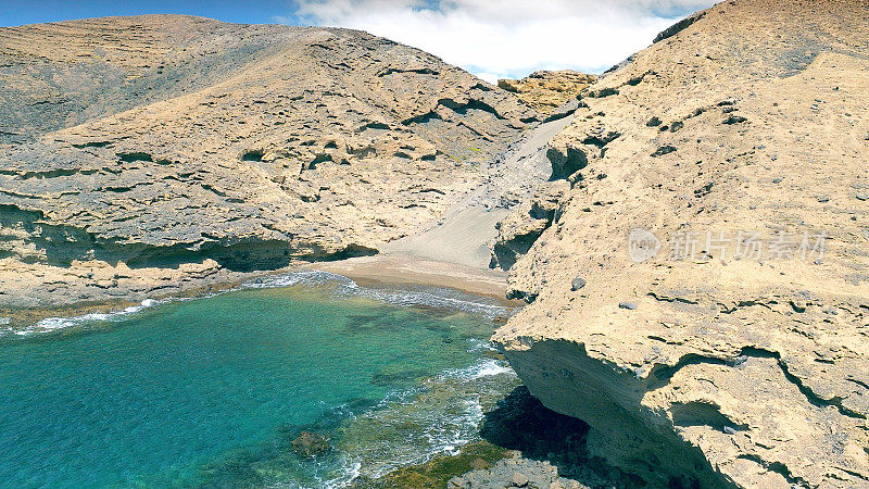 Aerial view of the hidden cove beach "La Rajita" at the natural reserve of "Monta?a Pelada" in Tenerife (Canary Islands). Drone shot